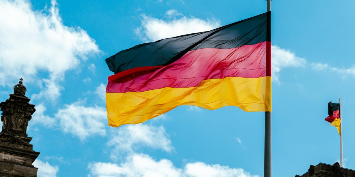 "Bandera de Alemania ondeando en el cielo, representando la enseñanza de alemán en Colombia para hispanohablantes.